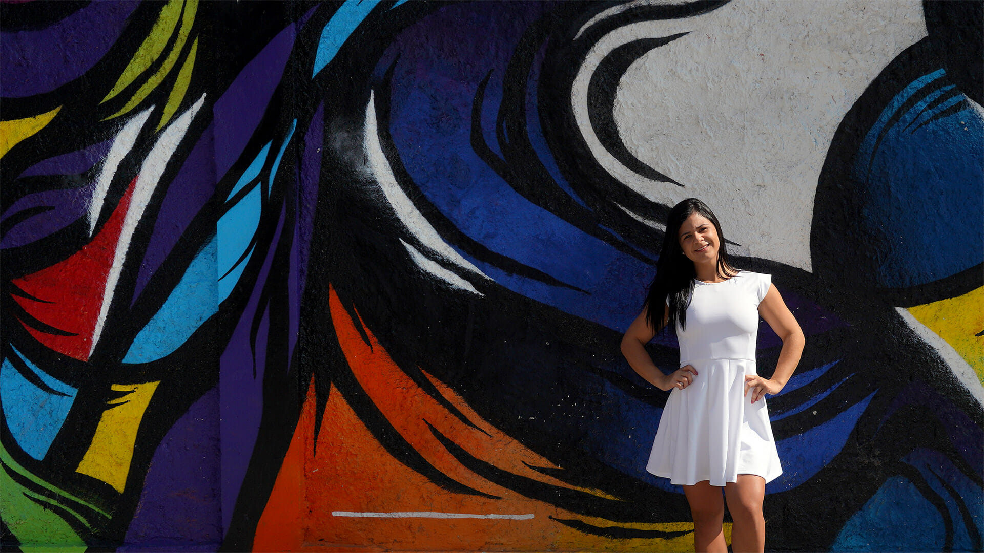 Menina em frente ao muro com grafite de vestido branco - Arte urbana