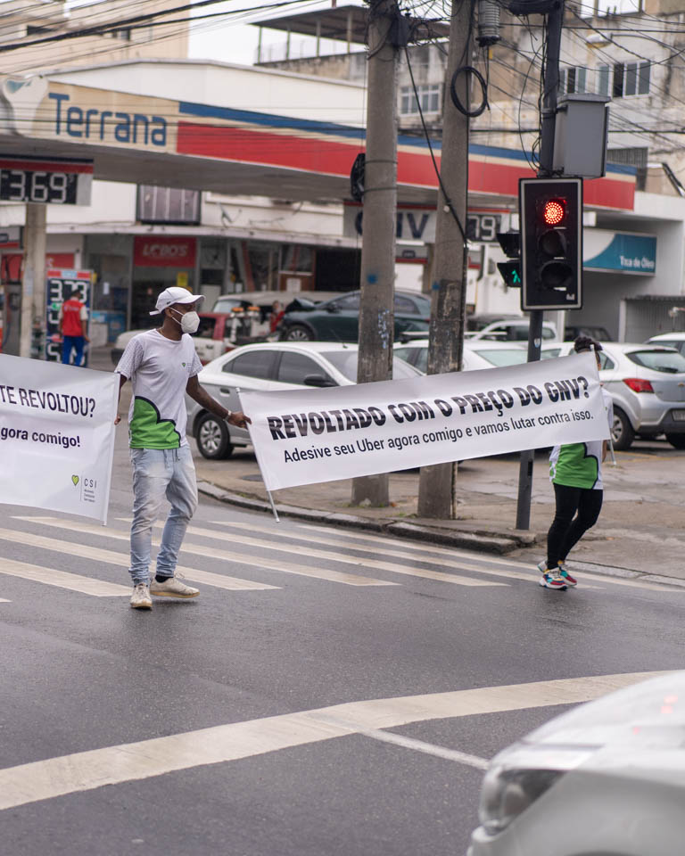 Ativistas segurando faixa do GNV no sinal alertando aos Ubers - Protesto