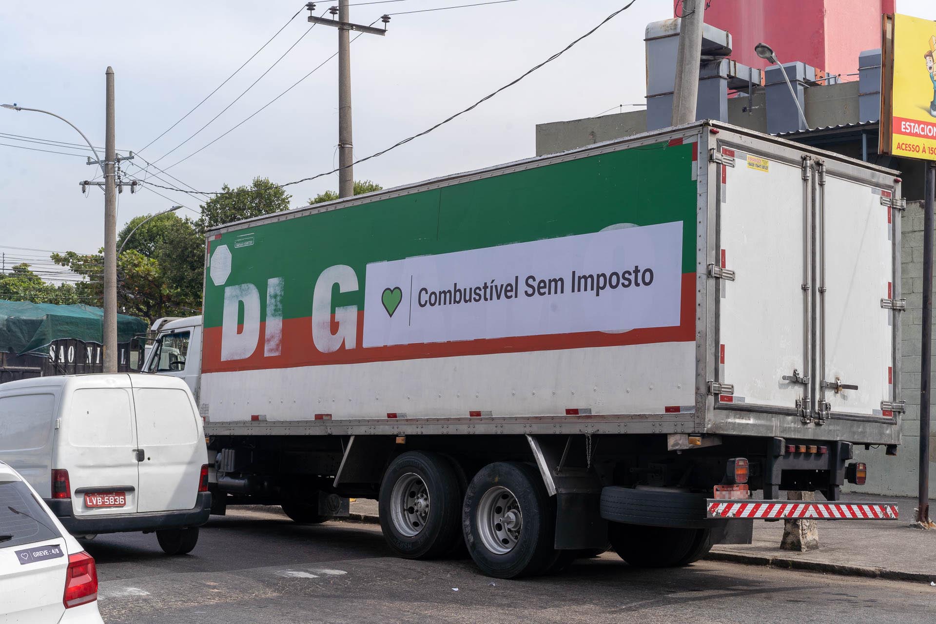 Caminhão verde e vermelho com adesivo do combustivel sem imposto de 4m