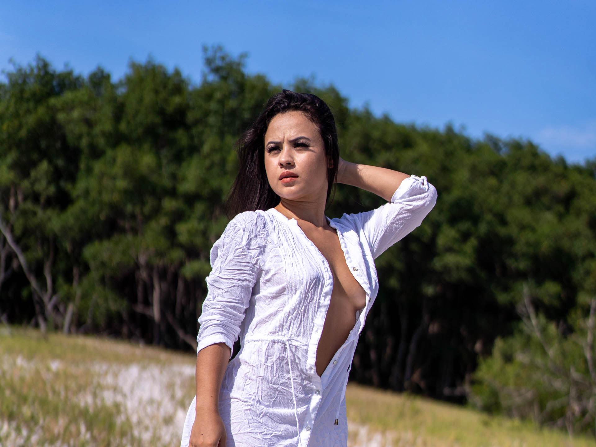 ensaio fotografico sensual com modelo nua se blusão branco em meio a natureza com ceu azul