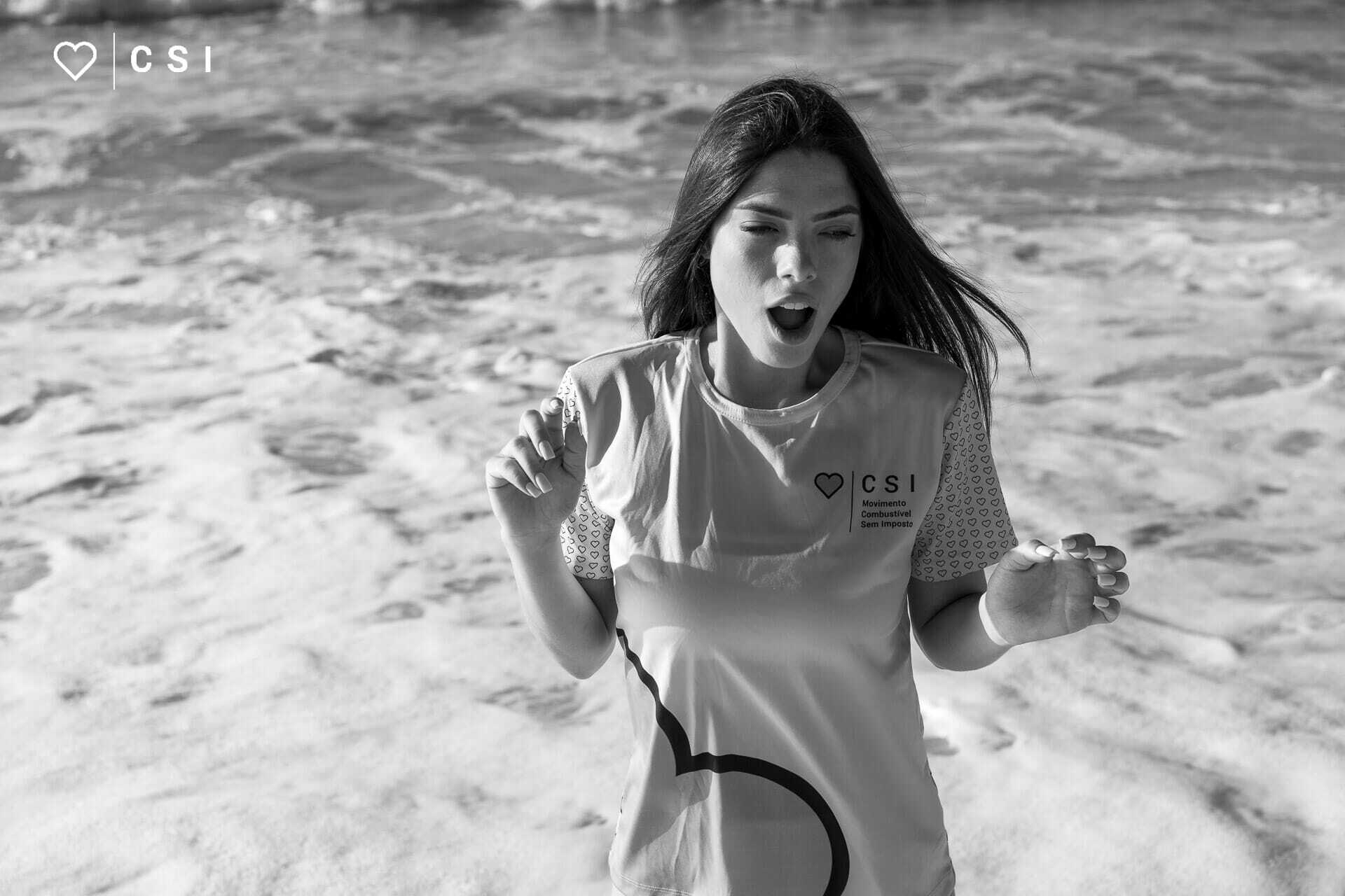Ensaio fotografico com modelo na praia tomando susto pela agua fria do mar do recreio dos bandeirantes - foto em preto e branco