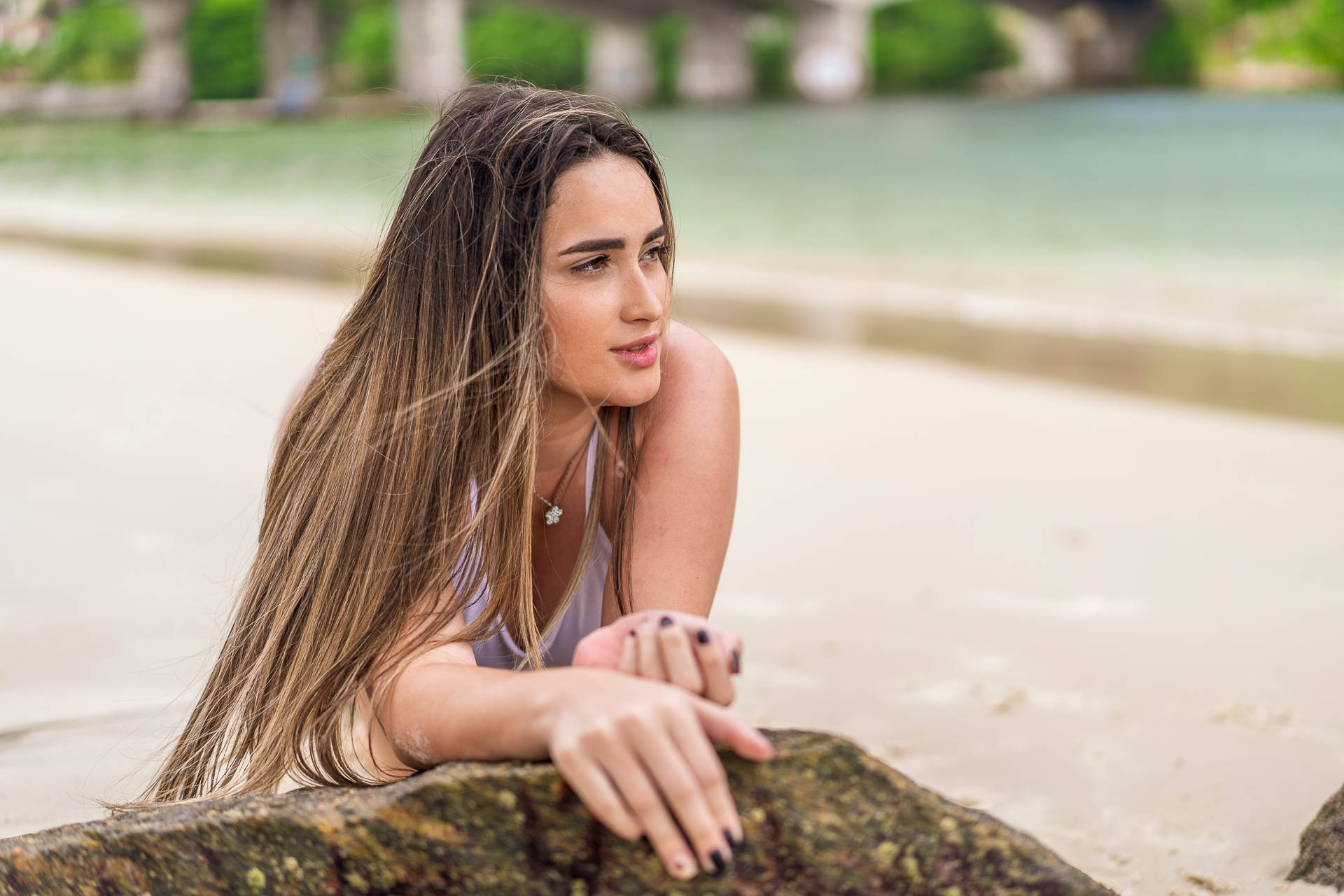 Modelo fotografica Ariane Lima de cabelos longos e lisos com maio branco em ensaio na praia para o combustivel sem imposto