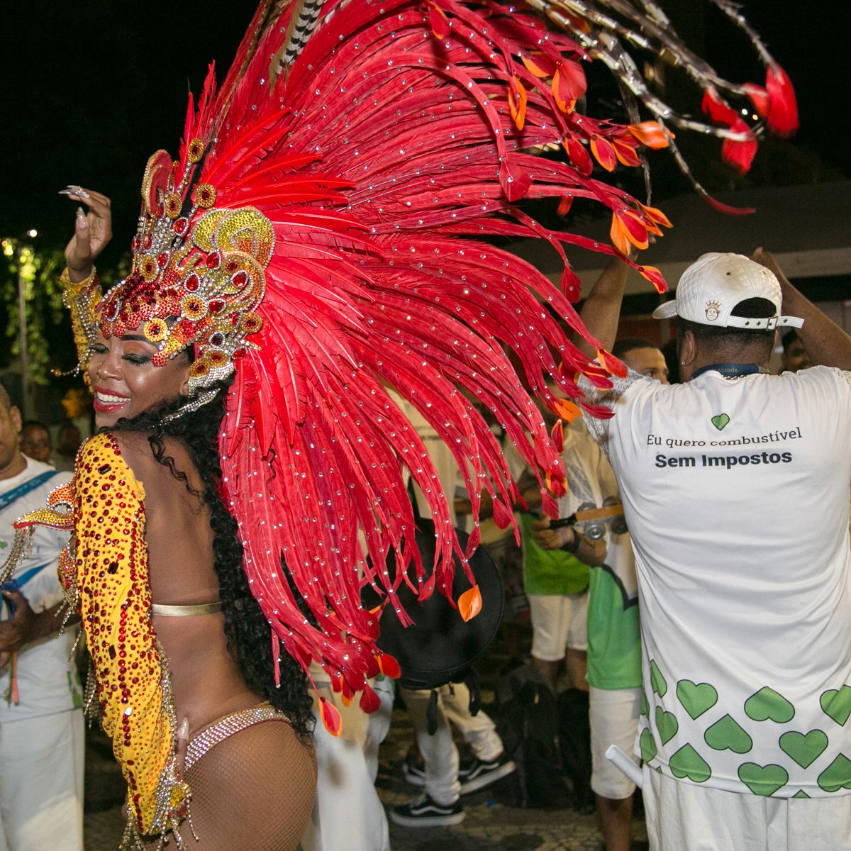 Passista de carnaval Patricia na cinelandia com plumas vermelhas na cabeça